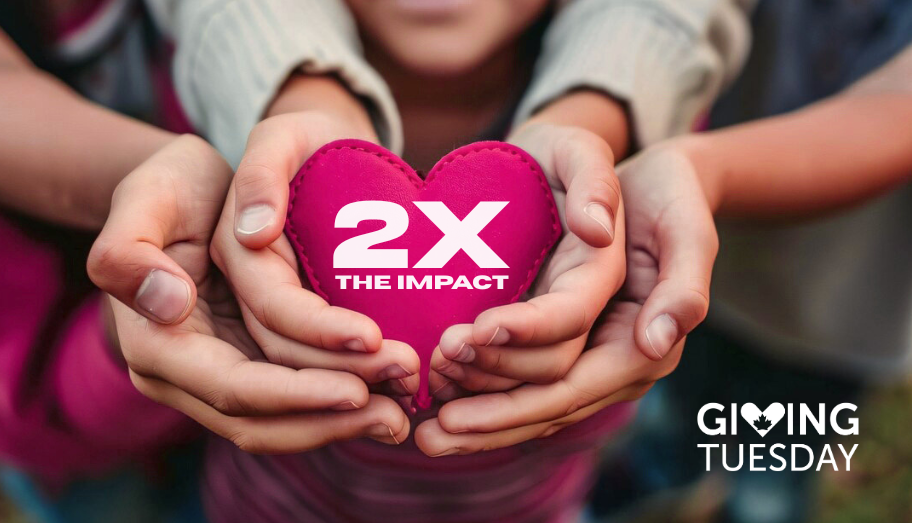 People, including a child, holding a fabric heart featuring a