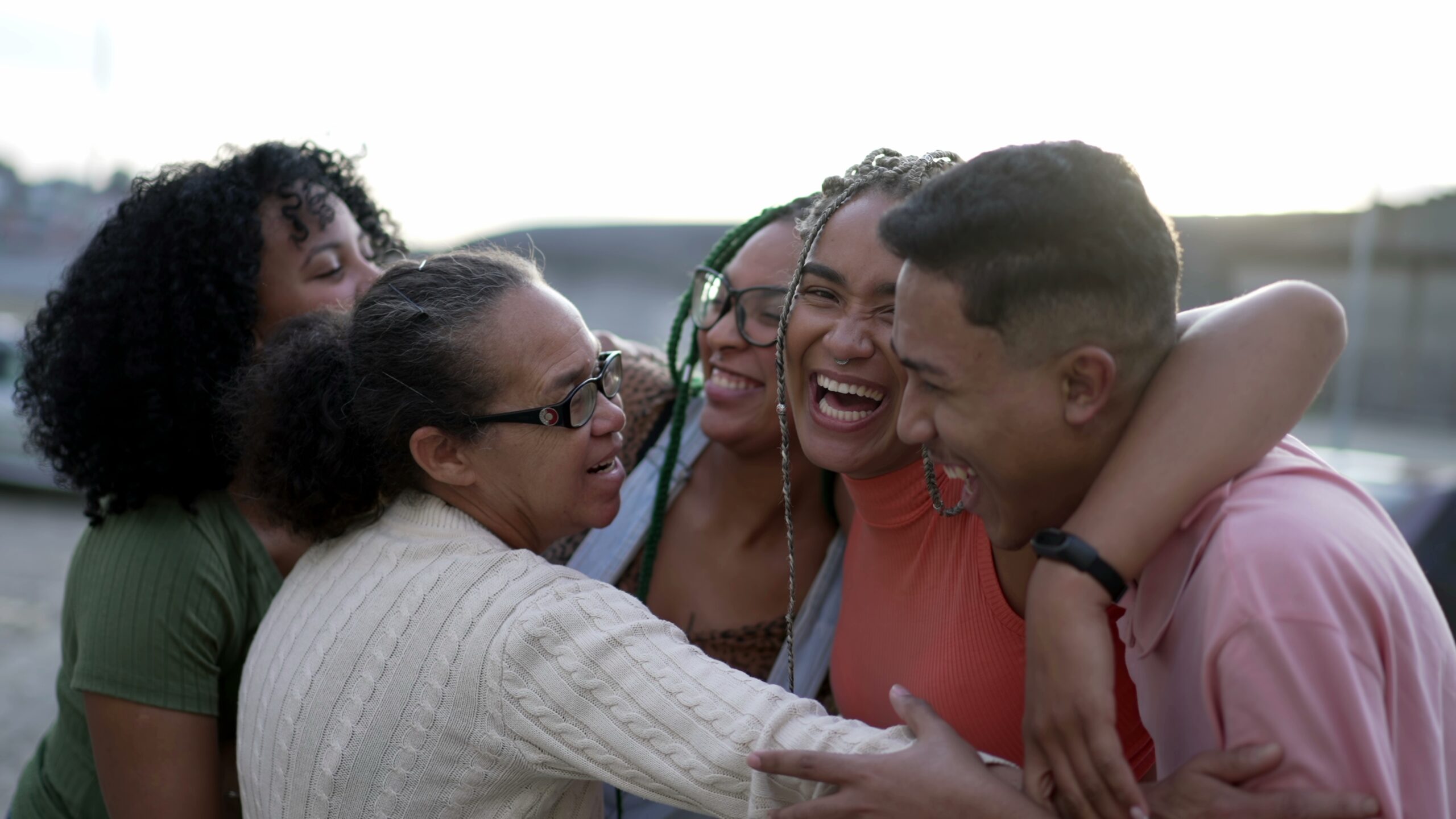 A multigenerational family of five embracing and smiling together.